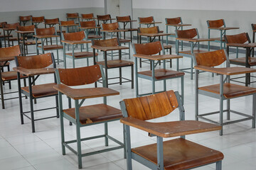 Empty classroom with vintage tone wooden chairs. Classroom arrangement in social distancing concept to prevent COVID-19 pandemic. Back to school concept.	