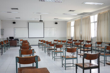 Empty classroom with vintage tone wooden chairs. Classroom arrangement in social distancing concept to prevent COVID-19 pandemic. Back to school concept.	