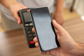 POS terminal for payment with smartphone, nfc technology. Cashier and customer hands