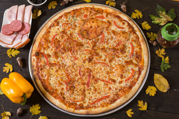 Fresh just made pizza with vegetables and ham, spices for pizza in restaurant.