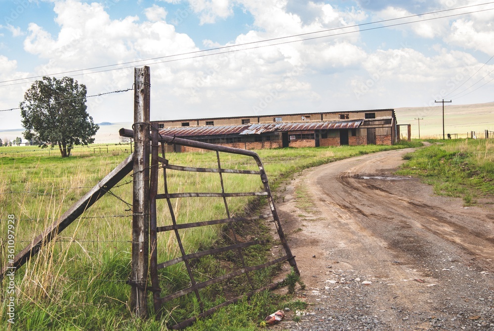 Canvas Prints Entrance of an old farmland with weathered metal gates