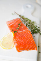 A piece of smoked salmon with thyme and lemon