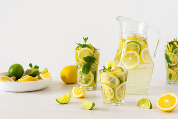 Summer refreshing drink of lemon, lime and mint, jug with lemonade and glasses and citrus slices