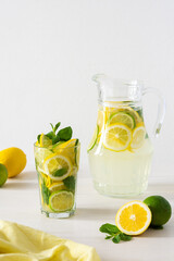 Summer refreshing drink of lemon, lime and mint, jug with lemonade and glasses and citrus slices