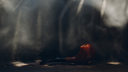 Smoking pipe on steel background with smoke.