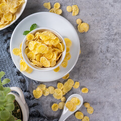 Corn flakes bowl sweets on gray cement background, top view flat lay layout design, fresh and healthy breakbast concept.