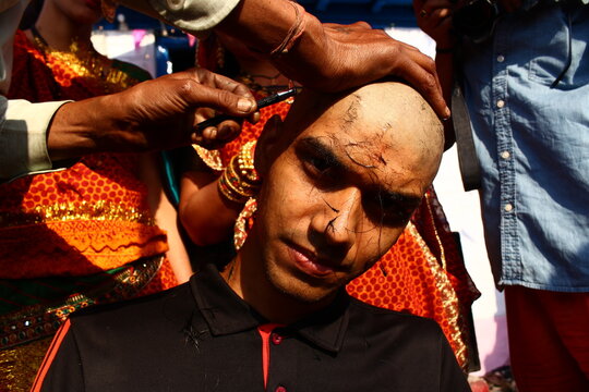 Almora, uttrakhand / India - May 26 2020 : A close of a hand and a head while cutting hairs, indian tradition of cutting hair during janew sanskar.