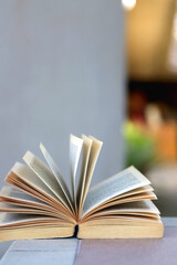Open book on a table in a yard. Selective focus.