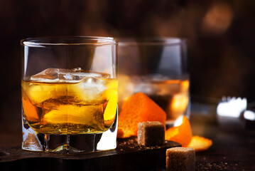 Old fashioned cocktail with bourbon, cane sugar, orange slice, cherry and orange peel garnish,...