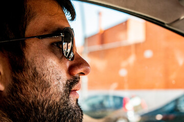 hombre con barba corta conduciendo, rostro concentrado 