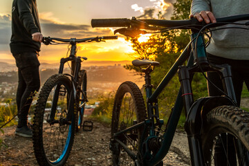 A couple of mountain bikes at sunset on the background of the city. Traveling on mountain bike in...