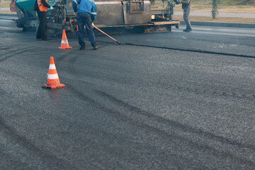 Fototapeta na wymiar Asphalt paving. Paver machine and road roller. New road construction