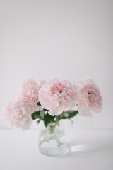 Beautiful pink peonies in a vase at home interior. Flower composition. Floral shop concept. Beautiful fresh cut bouquet. copyspace