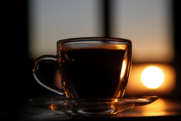 cup of coffee on the table at sunset