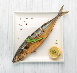 Baked whole fish grilled on a plate with vegetables and lemon