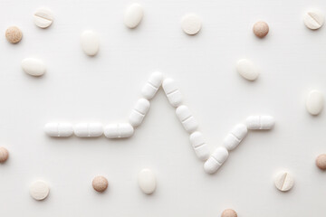 Tablets arranged in a line of life on a white background.