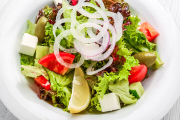 Fresh Greek salad in a bowl, top view