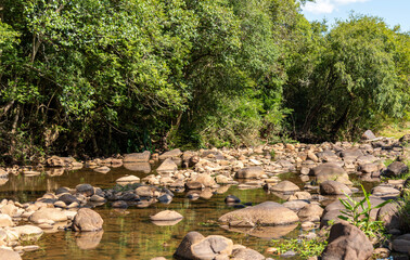Small stream of fresh water and rolled stones in the interior of Brazil