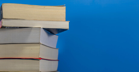 Stack of paper books on blue background
