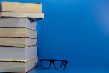 Stack of paper books on blue background