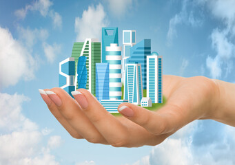 Fototapeta premium Female Hand Holding Futuristic Cityscape Over Blue Sky Background, Collage