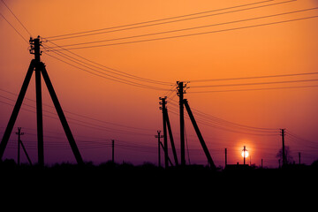 Fototapeta na wymiar poles of electrical lines in the sunset background