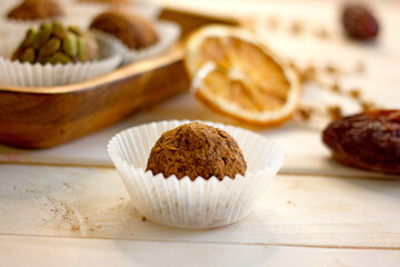 Raw food candy. Handmade vegan sweets made from almonds, walnuts, dates, raisins, coconut and cocoa. Raw food candies in coconut and cocoa close-up. Healthy vegan sweets concept.