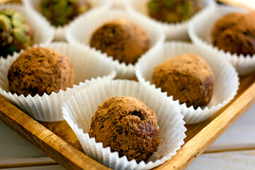 Raw food sweets handmade balls of seeds, nuts, dates and coconut, close-up