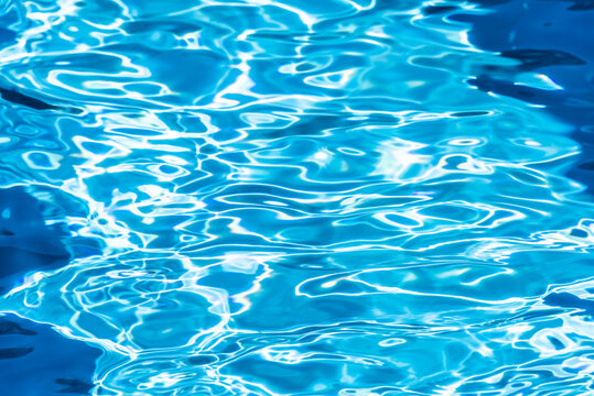 Repeating summer pattern of photographed, living water surfaces in a pool, with the emphasis on light refraction where you can see the sprinkled ground moving along with the waves