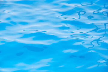 Repeating summer pattern of photographed, living water surfaces in a pool, with the emphasis on light refraction where you can see the sprinkled ground moving along with the waves