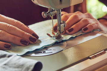 Woman tailor using retro sewing machine at home, hobby concept.