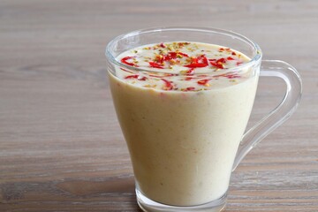 Apple oats milkshake garnished with Cherry . Close up view of a glass of milkshake 