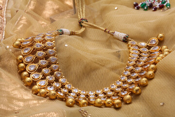 close up kundan indian wear chain gold choker on a brown backdrop