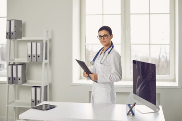 Woman doctor pediatrician standing in the white office of the hospital.