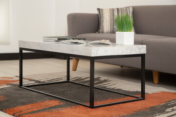 marble table detail with a glass vase in the home, with sofa and nice carpet