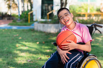 Asian special child on wheelchair is playing basket ball to strengthen muscles in the outdoor park, Lifestyle of disability child, Life in the education age, Happy disabled kid in homeschool concept.