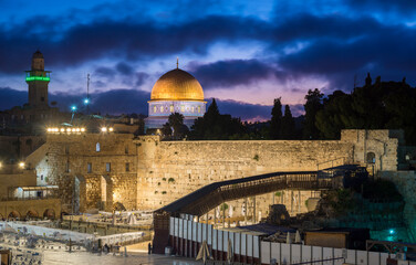 Dramatic purple dawn sky over the Temple Mount and the Western Wall, the holiest place in Judaism, with its plaza divided into sections because of Israeli COVID-19 restrictions on places of worship