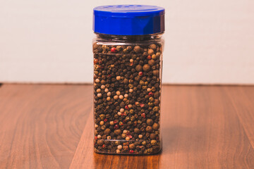 Black, red, white pepper. Allspice in a spice jar. Heap of spice. Mix of different peppers