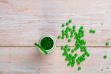 Home therapy. Round green vitamin pills on wooden table