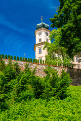 Historical chateau at Mnisek pod Brdy city, Czech Republic. View of ancient building with towers, built in gothic style. Sunny summer day, blue sky and vibrant colors.