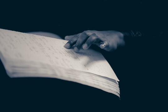 close up hand of a blind person reading braile book