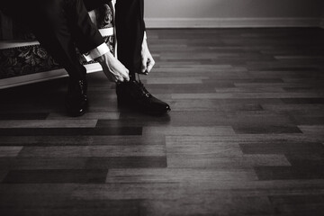 The groom puts on shoes. Preparing for the wedding.