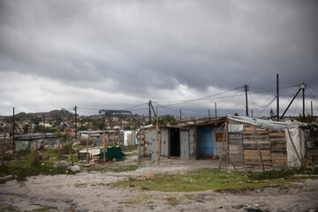 Fototapeta na wymiar Informal Settlement in a Township with gloomy grey cloud sky in Cape Town South Africa