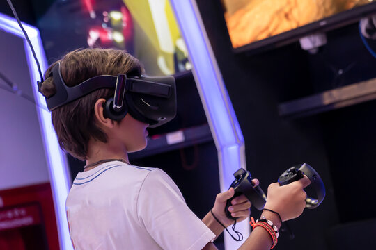 a boy with 3d glasses plays a game in virtual reality in a slot machine salon, modern technology