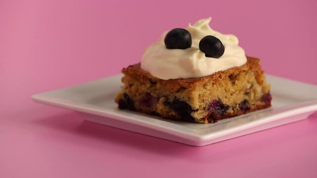 Serving a blueberry blondie brownie with whipped cream on top
