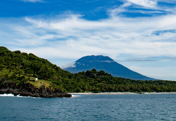 View of Agung volcano on a sunny day against the backdrop of a green rainforest from Gili Island, Indonesia