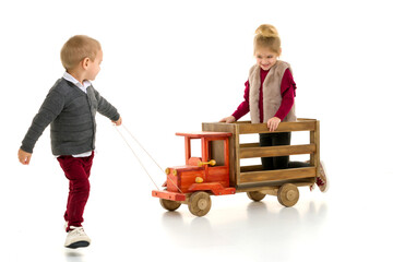 Brother and sister are playing with a toy car.