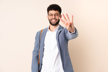 Young business Moroccan man isolated on beige background happy and counting four with fingers
