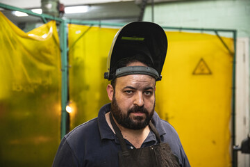 Portrait of male factory worker wearing welding mask at the factory