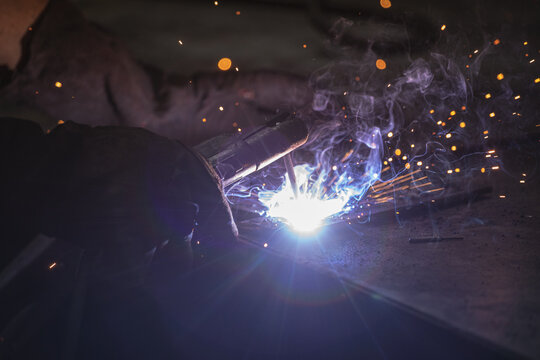 Close-up of a male factory worker welding at the factory
